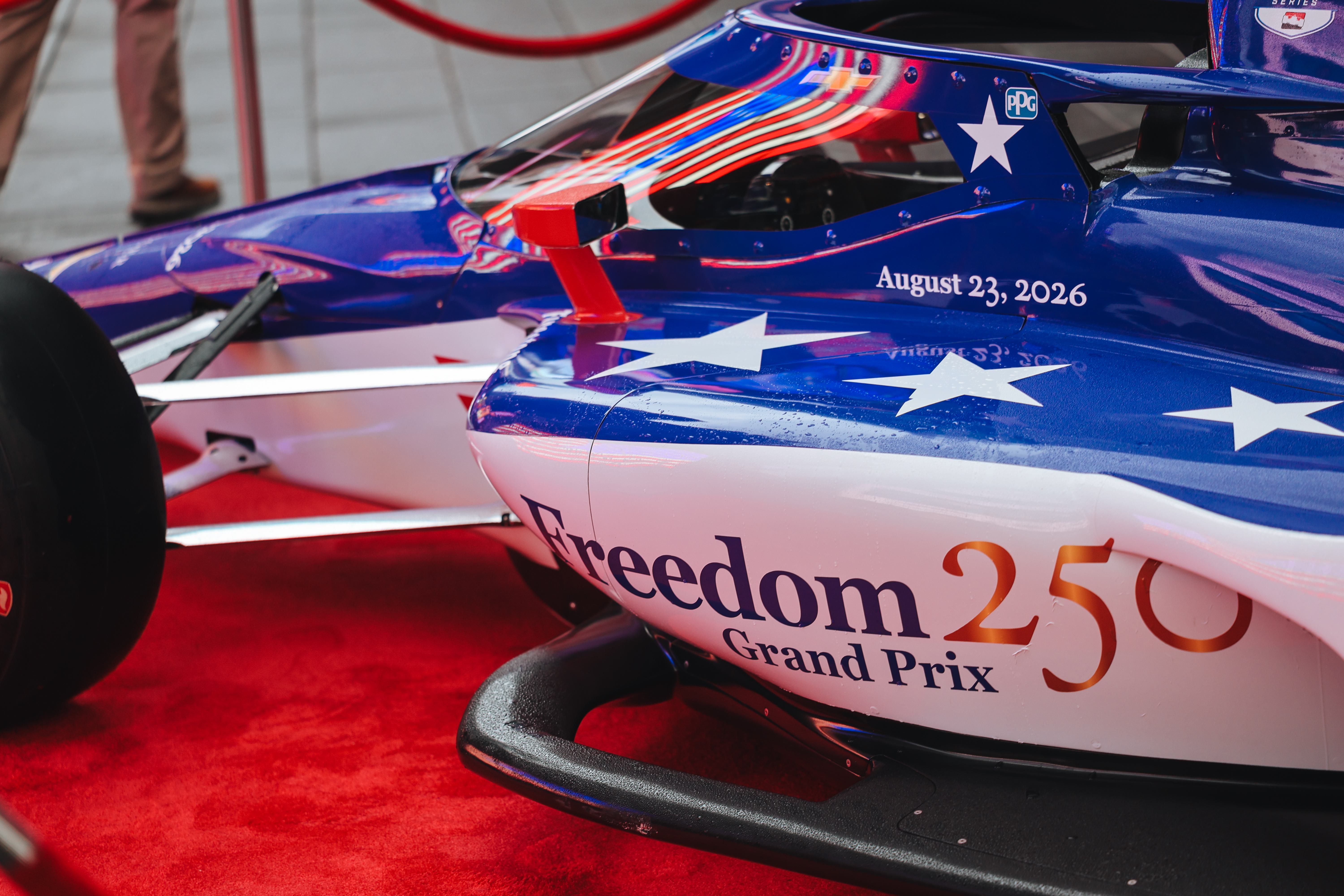 An INDYCAR car reading "Freedom 250 Grand Prix".